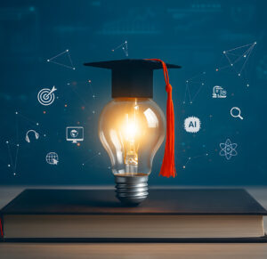 A lightbulb with a graduate cap on it sitting on a laptop